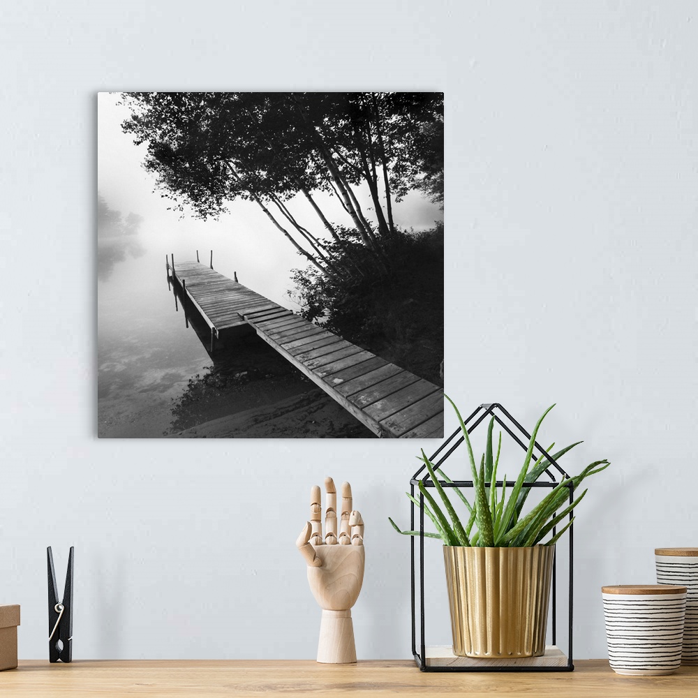 A bohemian room featuring Black and white photograph of a dock jetting out over a foggy lake in the countryside.