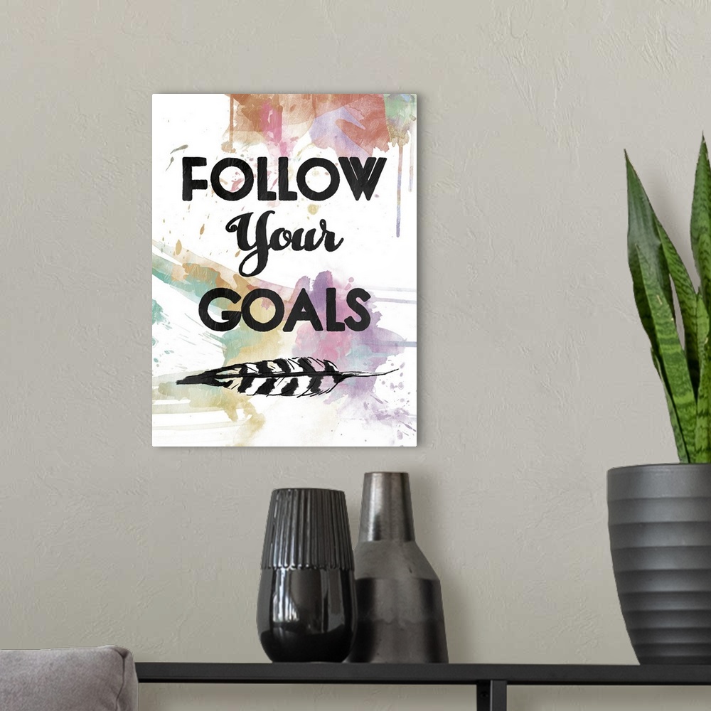 A modern room featuring A watercolor painting with the phrase ?Follow Your Goals? in black with a feather underneath and ...