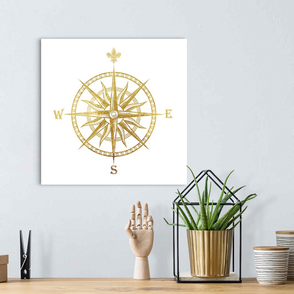 A bohemian room featuring Gold foil compass with the fleur de lis used for the "N"on a white background.