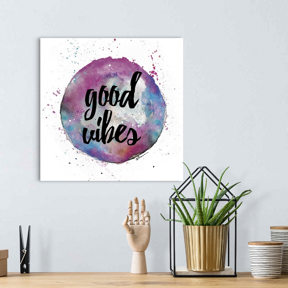 A bohemian room featuring A watercolor sphere in pink and blue shades with hand-lettered text inside.