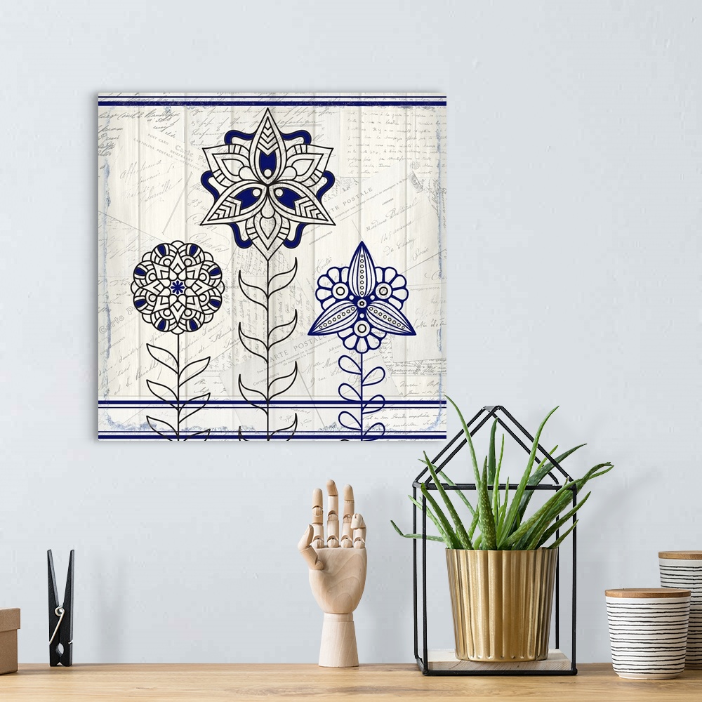 A bohemian room featuring A black and blue symmetric design of three flowers with a collage of handwritten postcards in the...