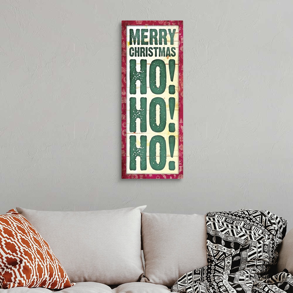 A bohemian room featuring Vertical Christmas typography art in deep green with a red edge.