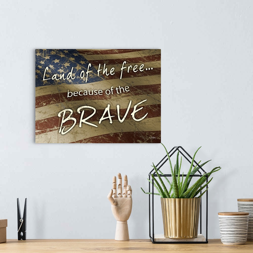 A bohemian room featuring "Land of the Free Because of the Brave" on a rustic waving American flag.