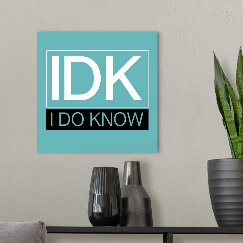 A modern room featuring Typographical artwork with a solid teal background and white text "IDK" in foreground.