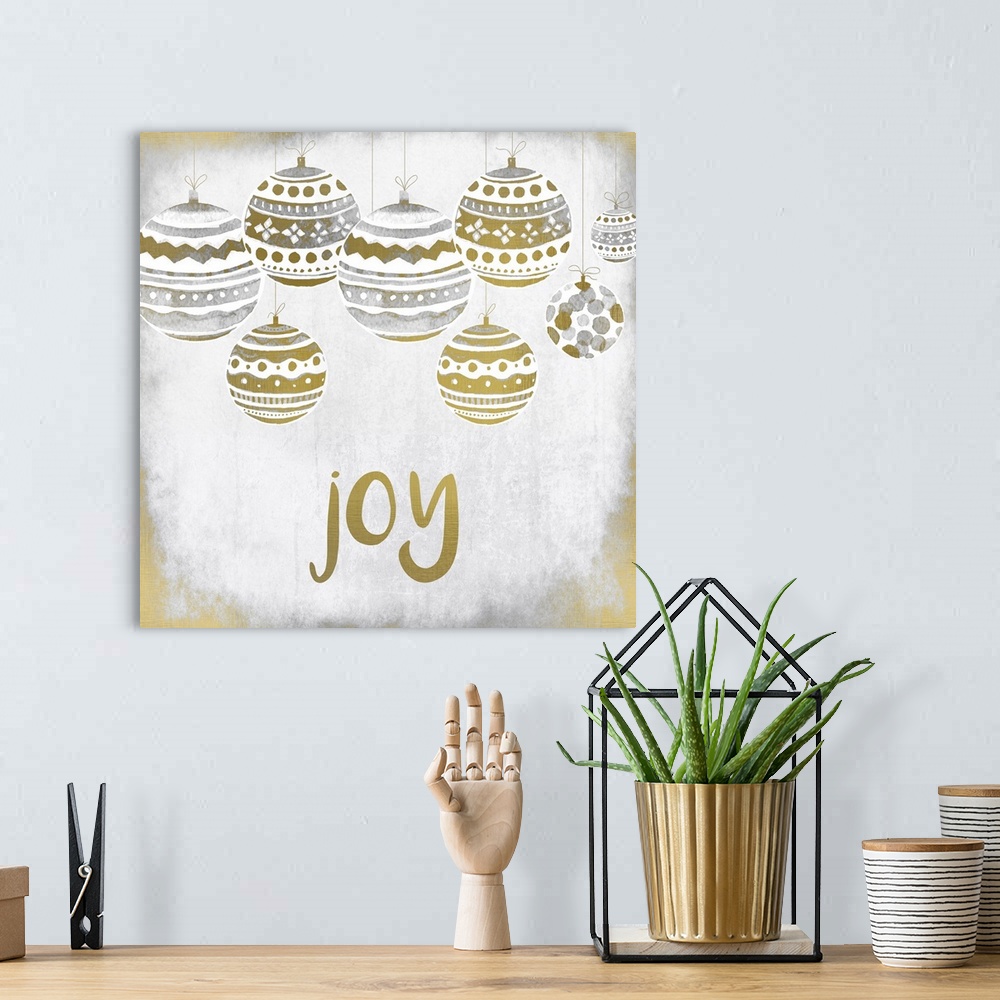 A bohemian room featuring Gold and silver holiday ornaments hanging over the word "Joy."
