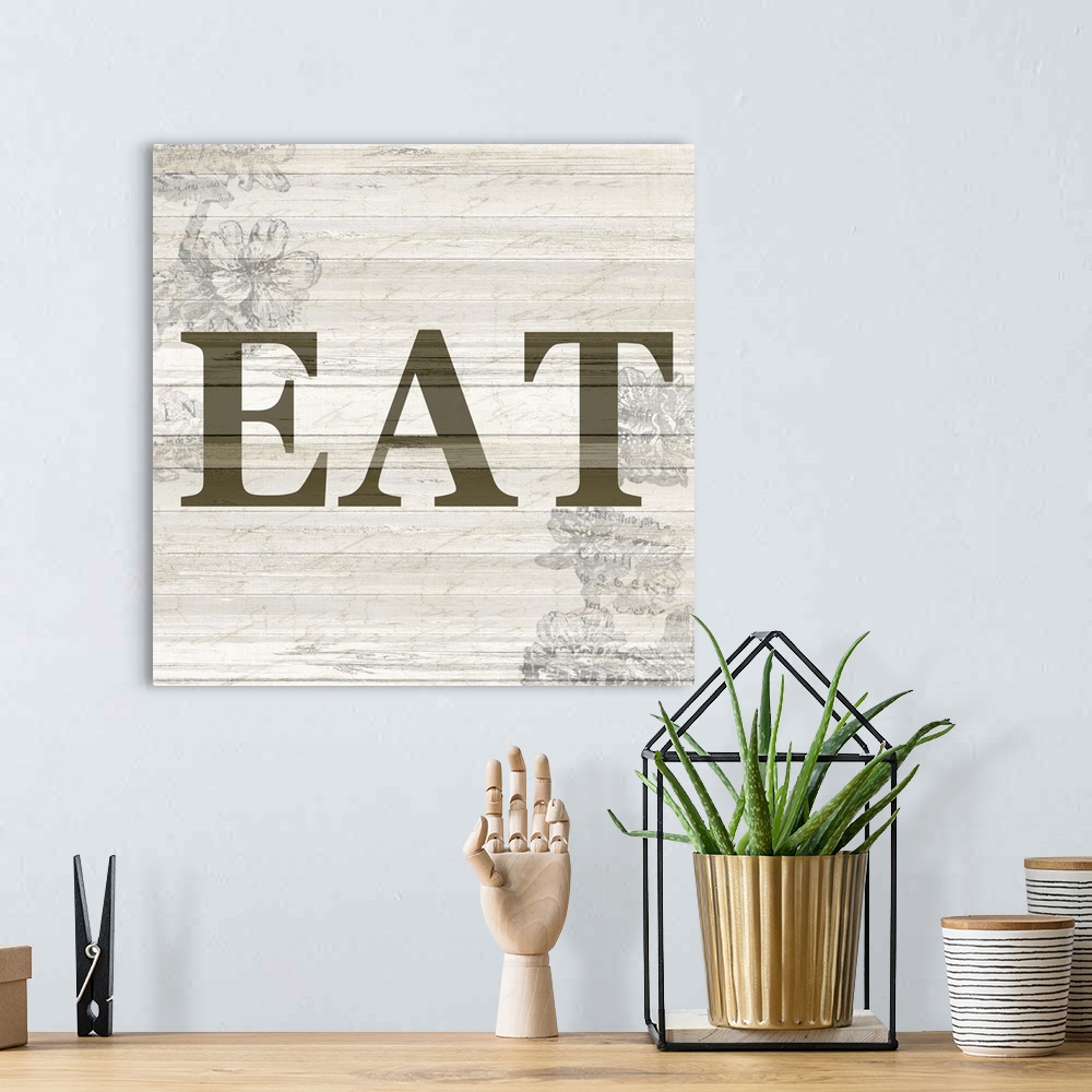 A bohemian room featuring The word ?eat? on a wood panel background with a faded floral design.�