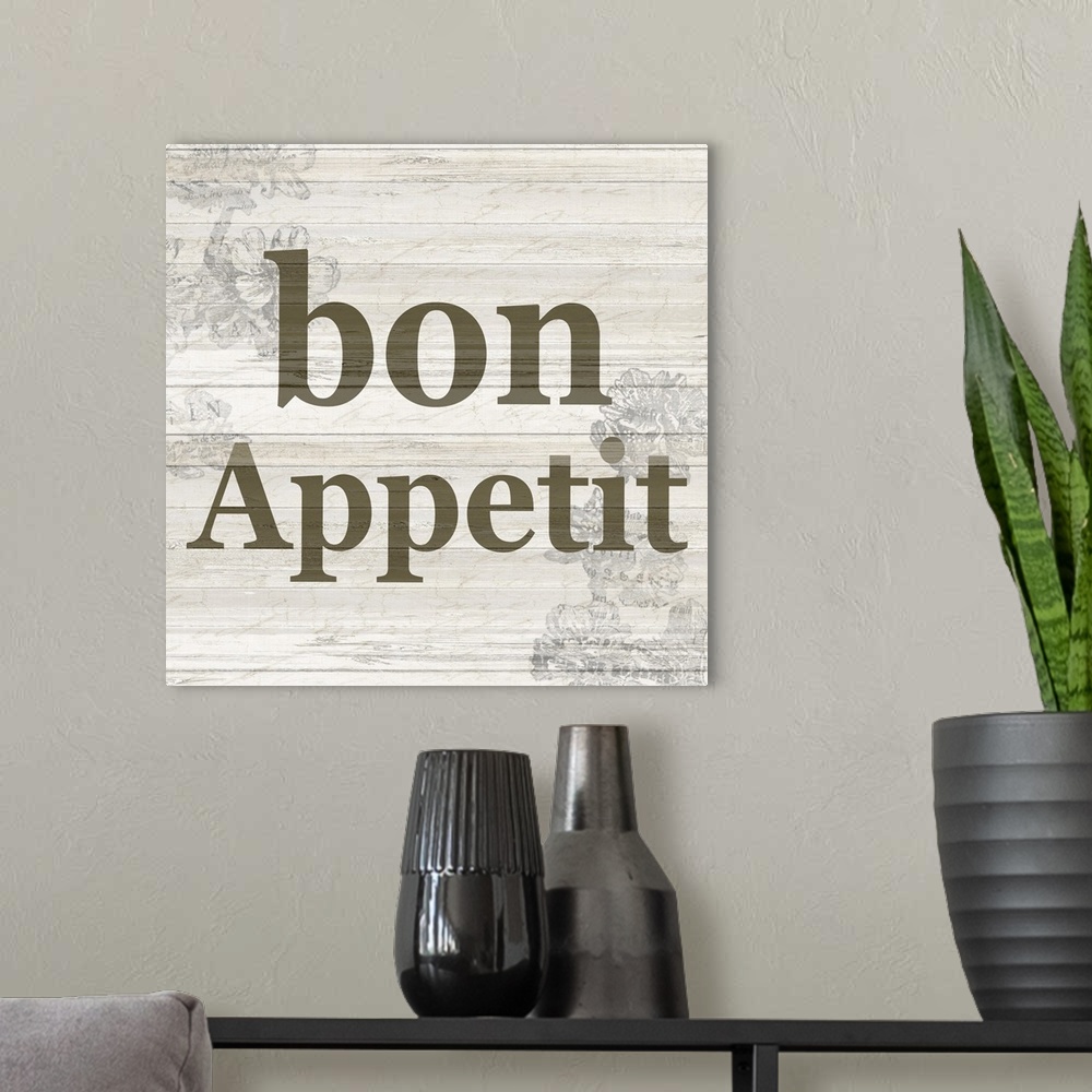 A modern room featuring The word ?bon appetit? on a wood panel background with a faded floral design.�