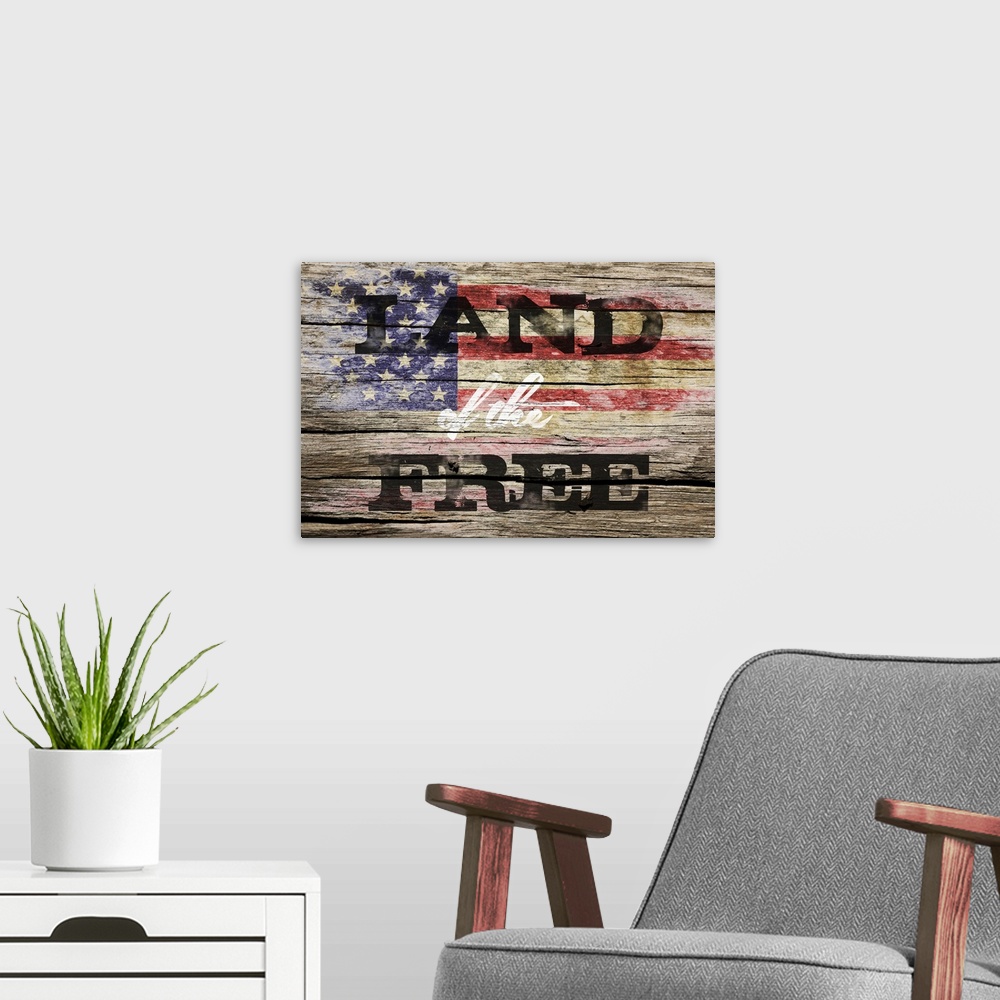 A modern room featuring The phrase ?Land of the Free? placed on a distressed wooden panel background with an American fla...