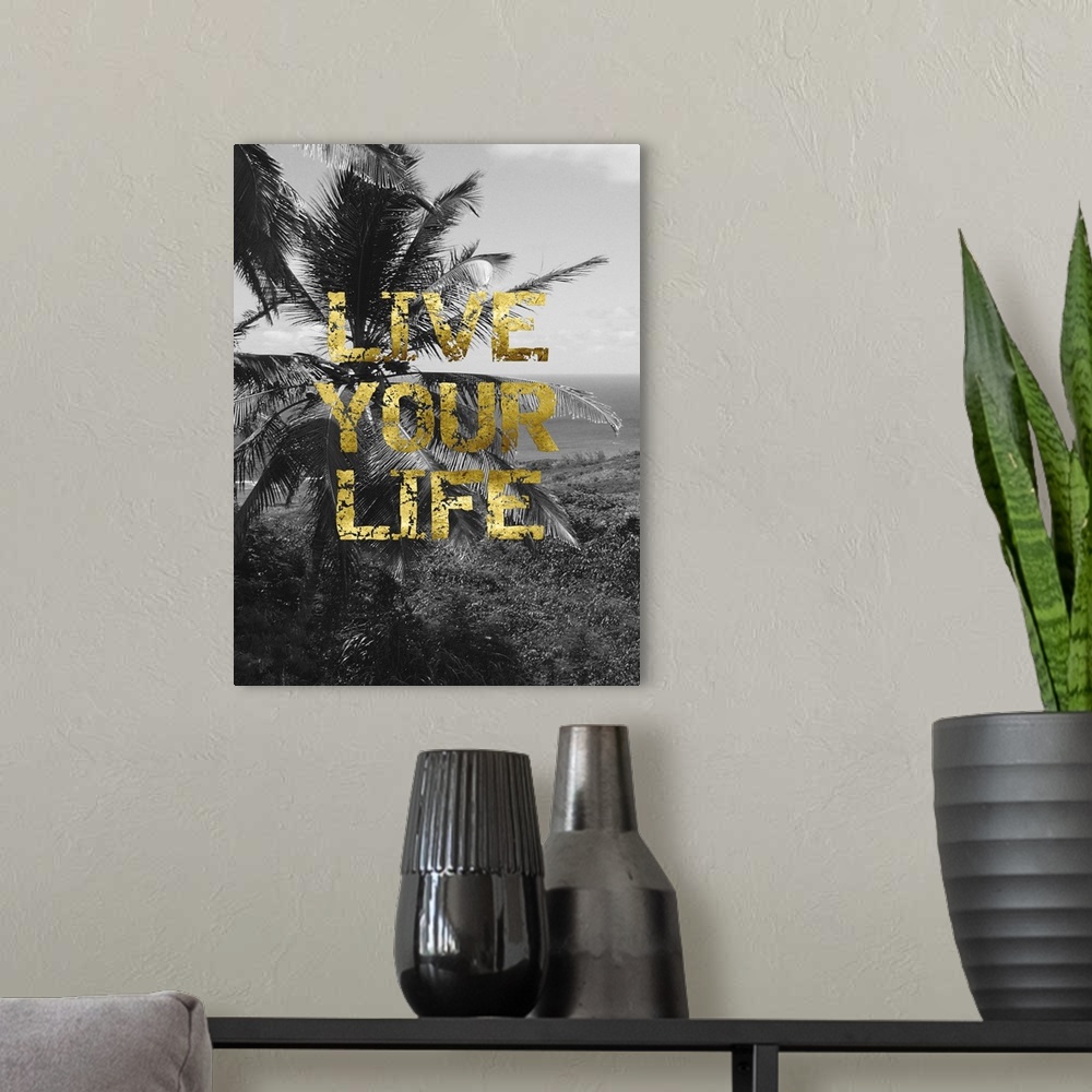 A modern room featuring "Live your life" written on top of a black and white photo of a beach scene with palm trees.
