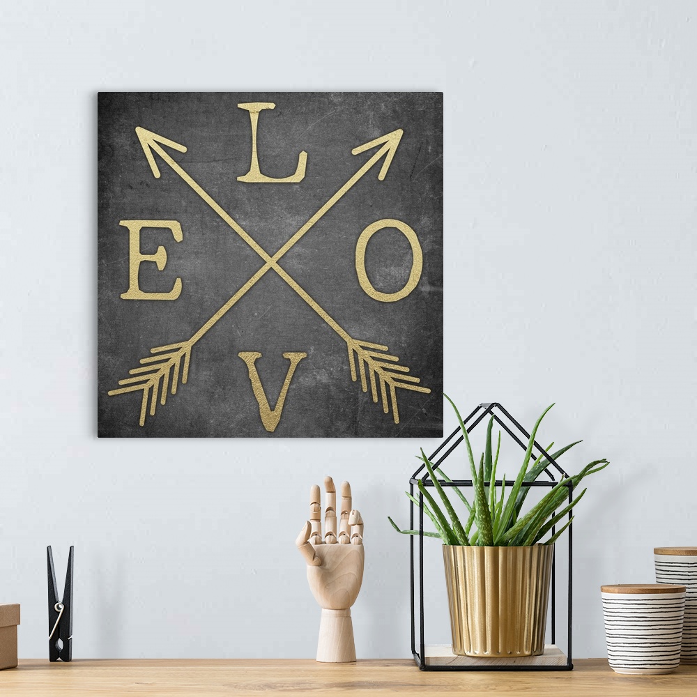 A bohemian room featuring Contemporary home decor typography artwork of the word LOVE in gold against a black background.