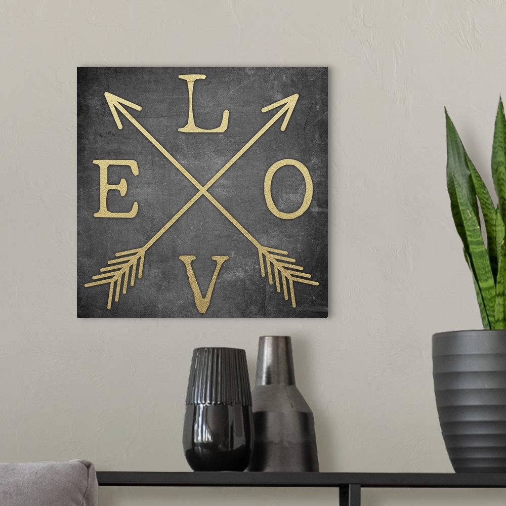 A modern room featuring Contemporary home decor typography artwork of the word LOVE in gold against a black background.