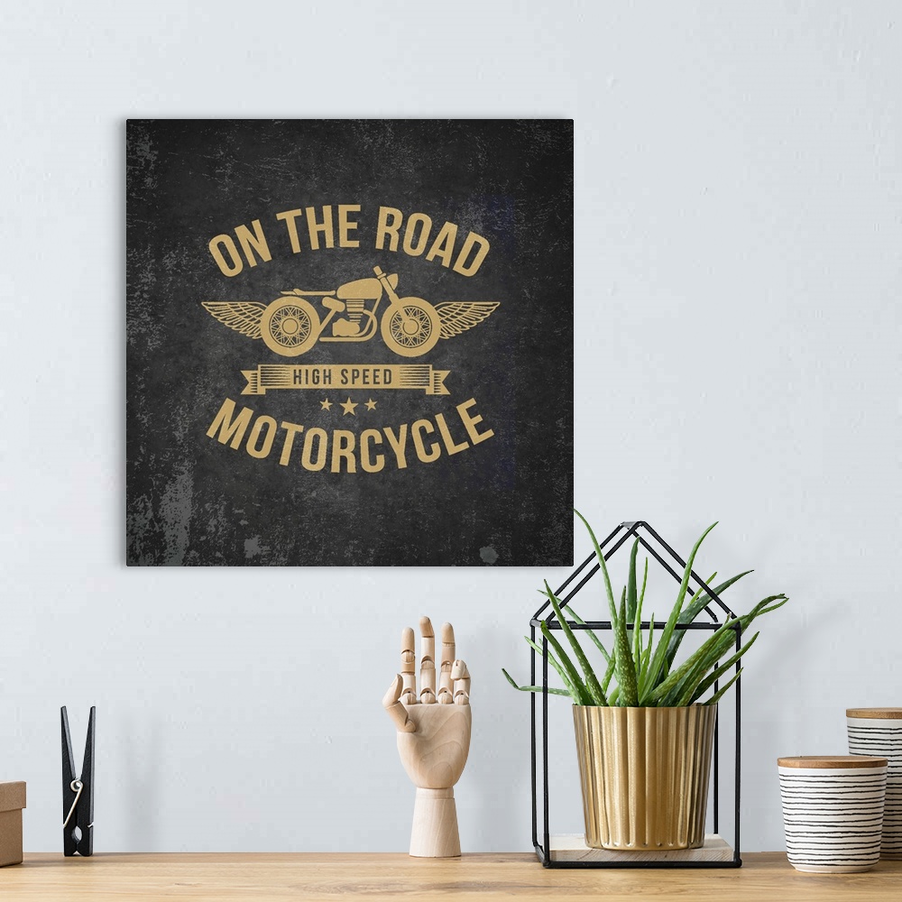 A bohemian room featuring Gold and black garage sign with a motorcycle and wings design.