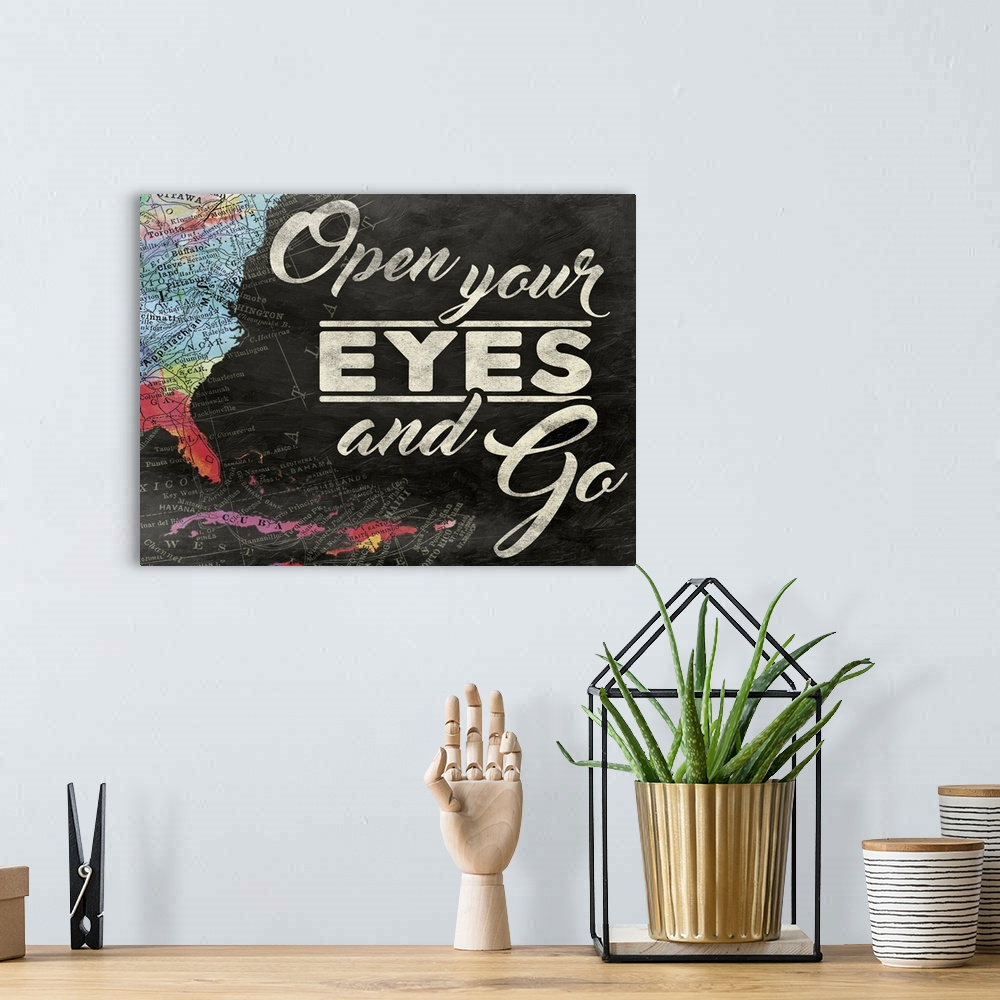A bohemian room featuring "Open Your Eyes and Go" painted on a chalkboard background with a colorful map on the left side.