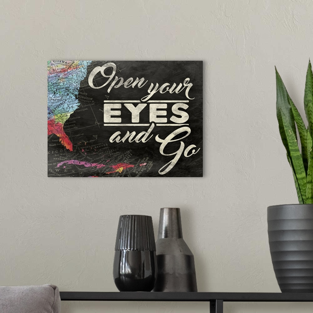 A modern room featuring "Open Your Eyes and Go" painted on a chalkboard background with a colorful map on the left side.
