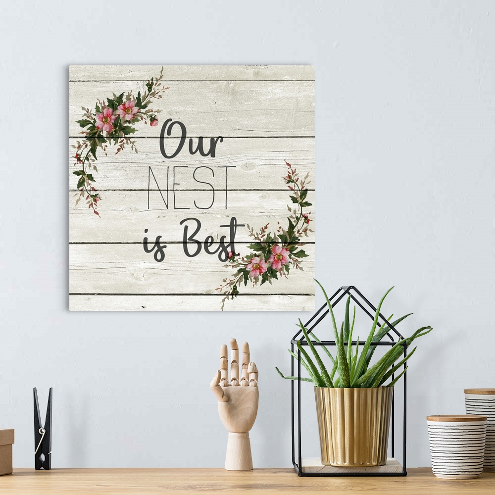 A bohemian room featuring "Our Nest is Best" with a wreath of flowers on a gray wood plank background.