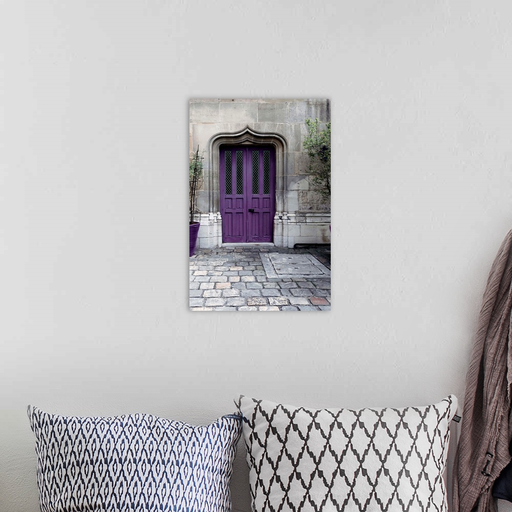 A bohemian room featuring Fine art photograph of a purple door in a stone wall on a cobblestone street.