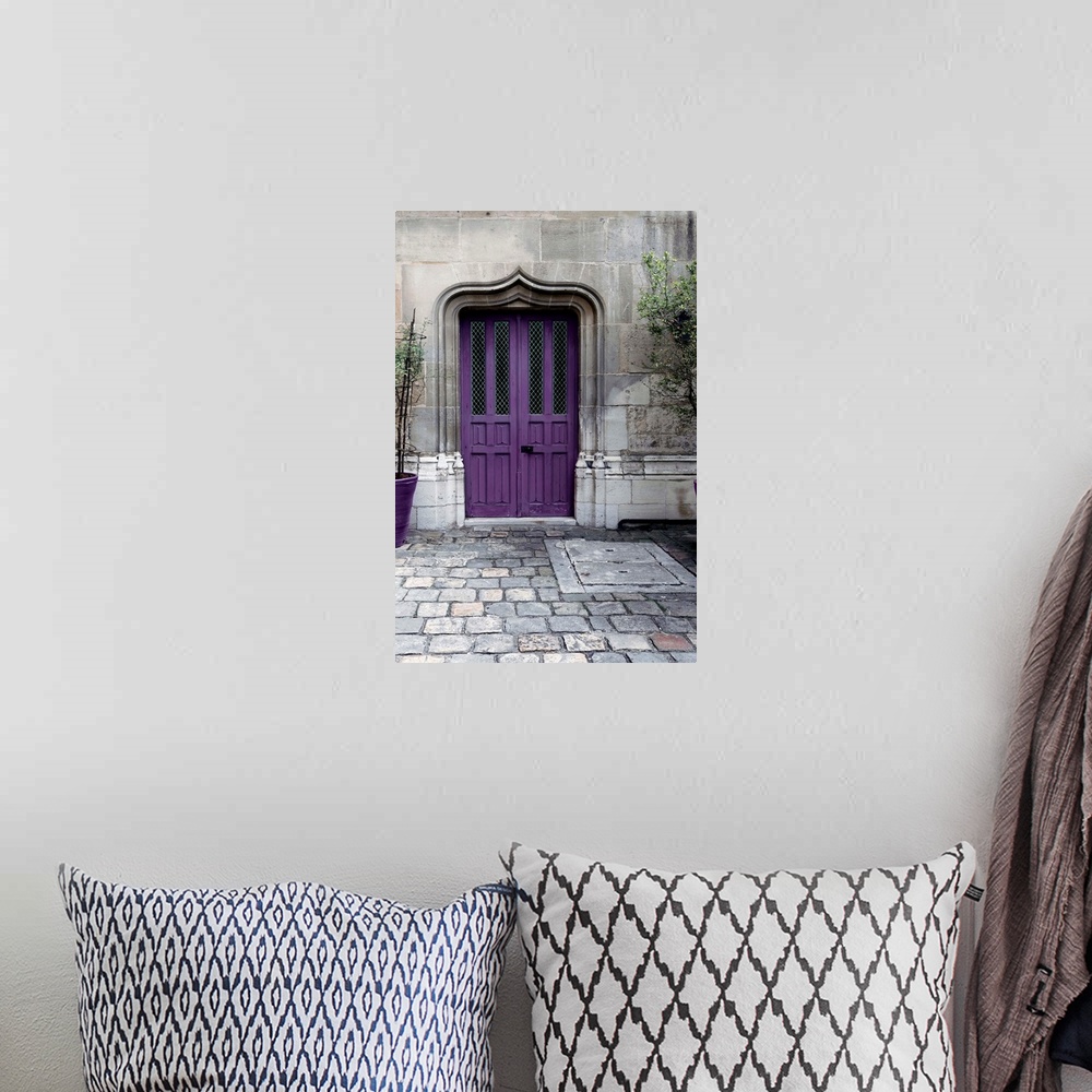 A bohemian room featuring Fine art photograph of a purple door in a stone wall on a cobblestone street.