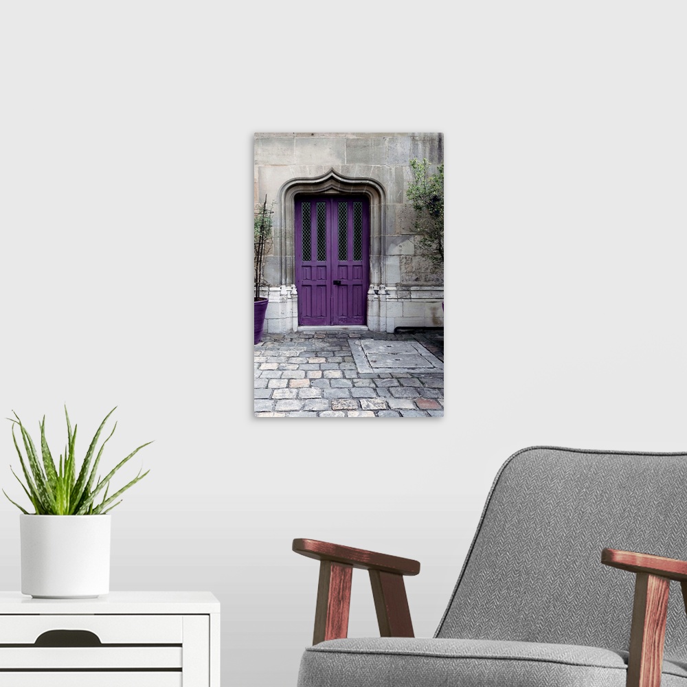 A modern room featuring Fine art photograph of a purple door in a stone wall on a cobblestone street.