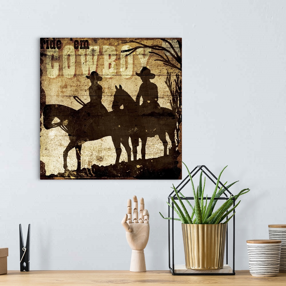 A bohemian room featuring A painting of a silhouette of two horses and cowboys in a desert scene with the phrase "Ride 'em ...