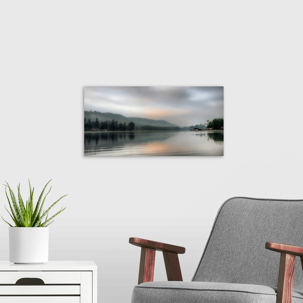A modern room featuring A cloudy sky in the early morning over coastal waters.