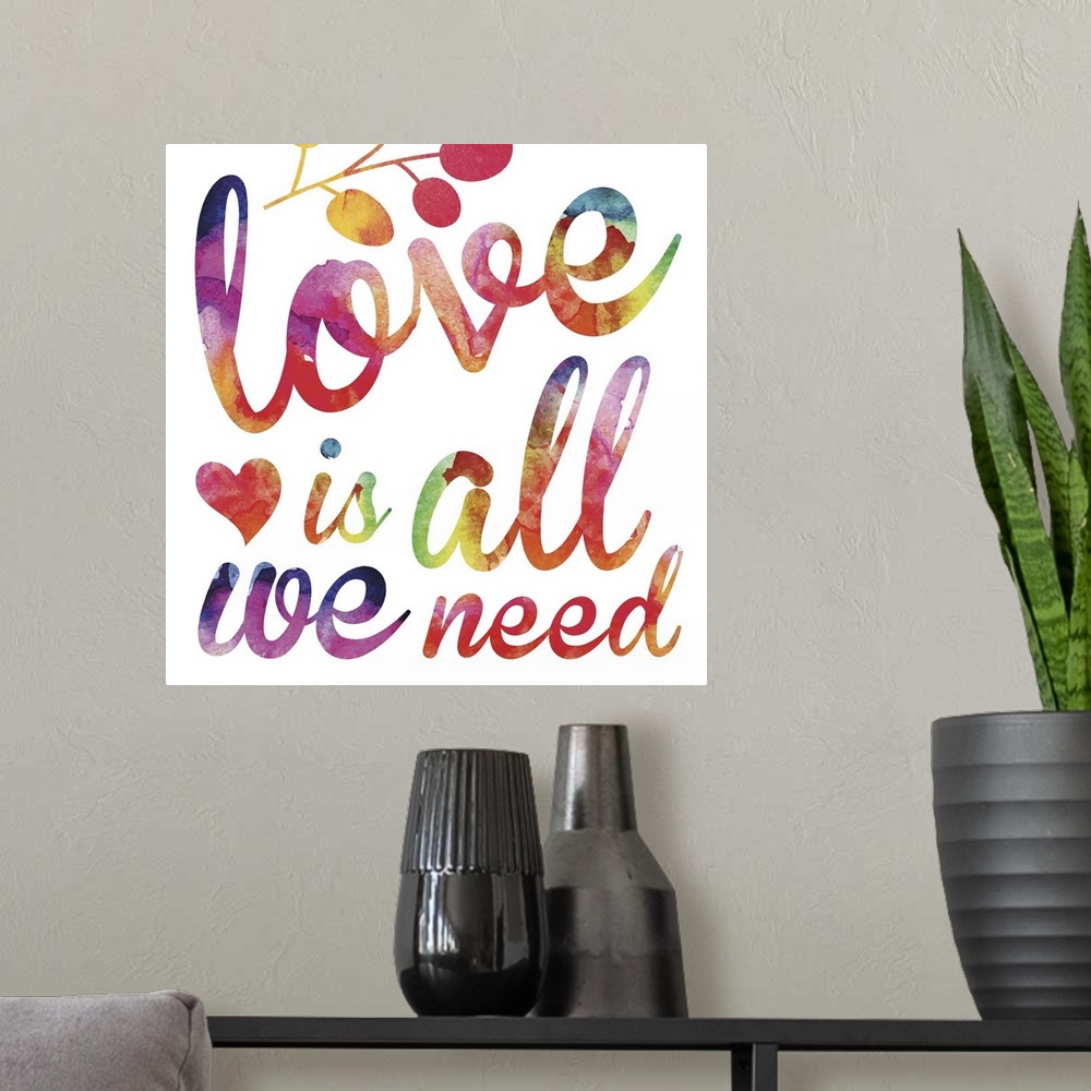 A modern room featuring "Love is all we need" in script lettering in  rainbow watercolors.