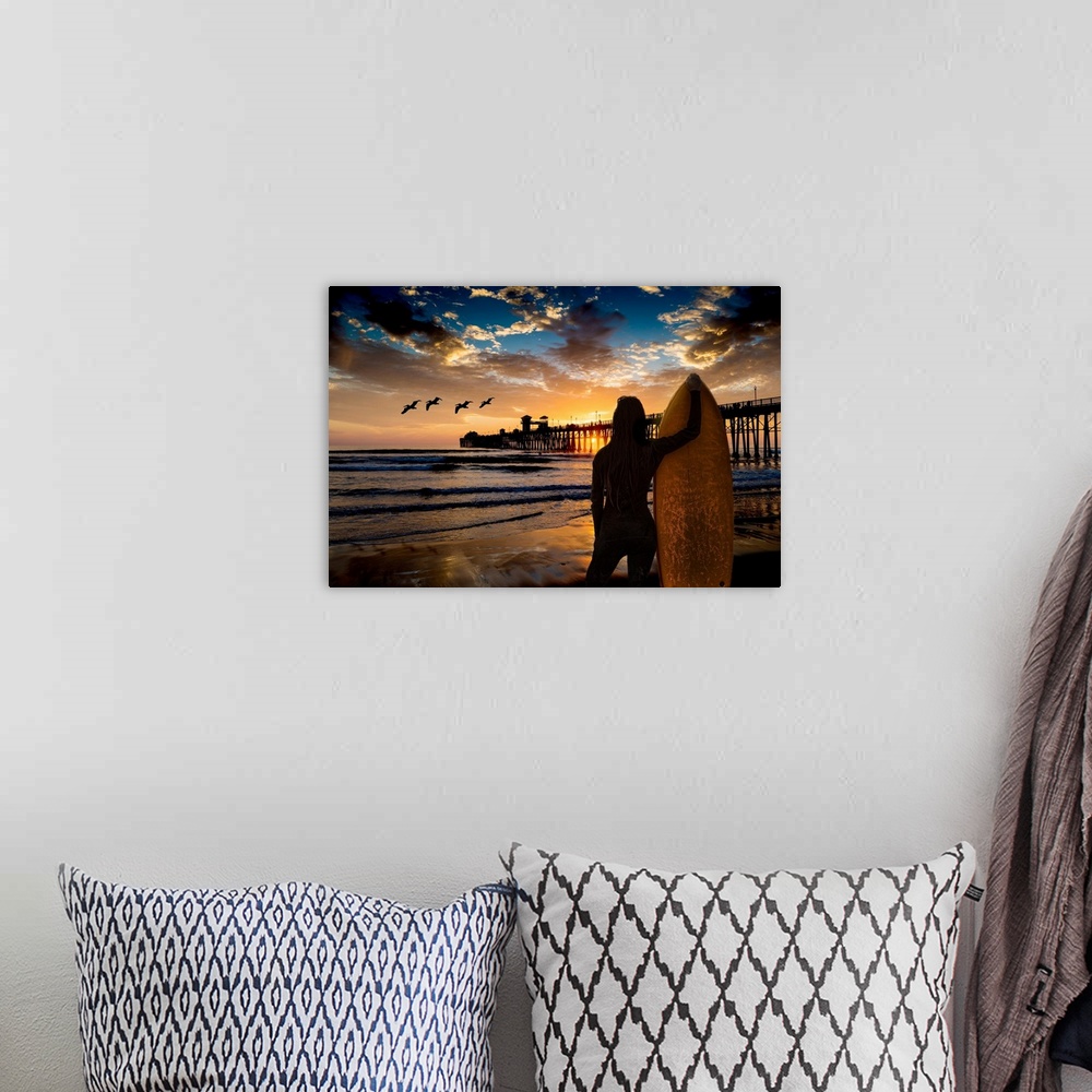 A bohemian room featuring A female surfer watches the last waves near the Oceanside Pier, Oceanside, California, USA