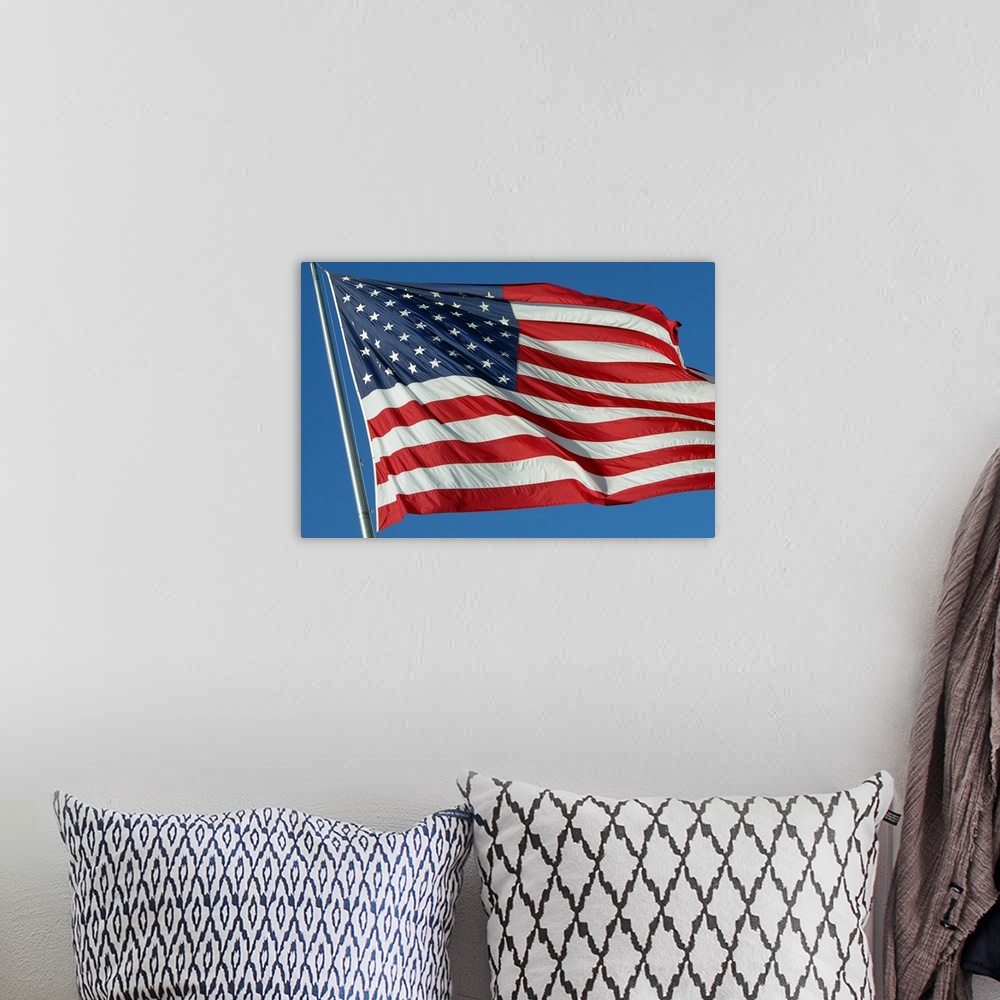 A bohemian room featuring A furled American flag waving during a blue sky day