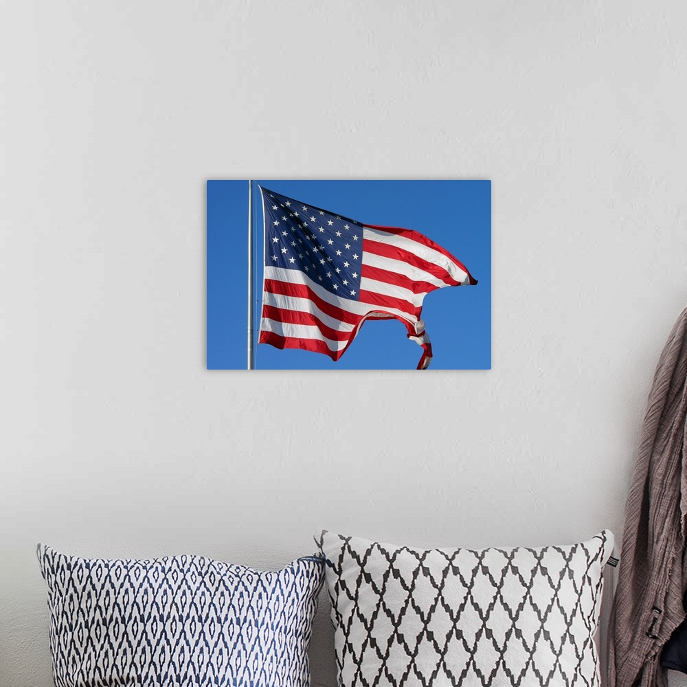 A bohemian room featuring A furled American flag waving during a blue sky day