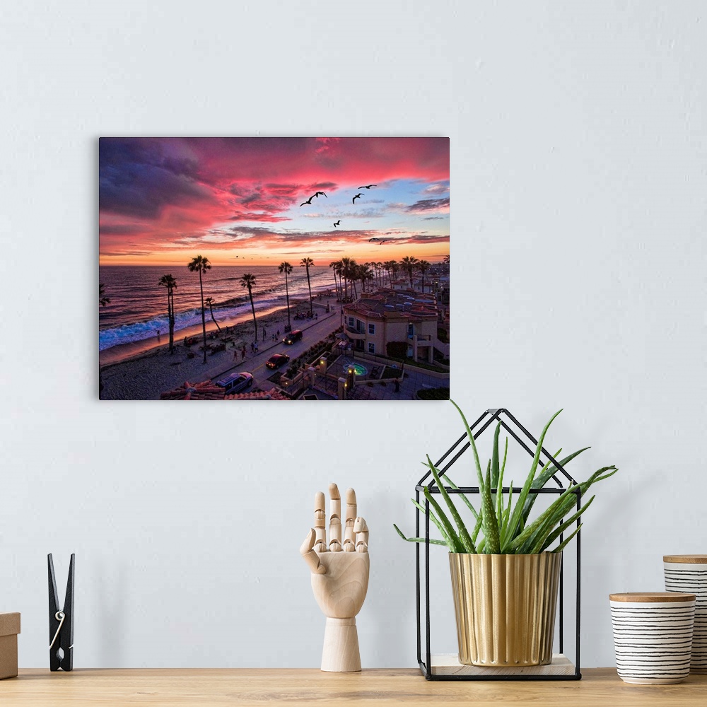 A bohemian room featuring Colorful sunset with seabirds passing over the coastline in Oceanside, California, USA.