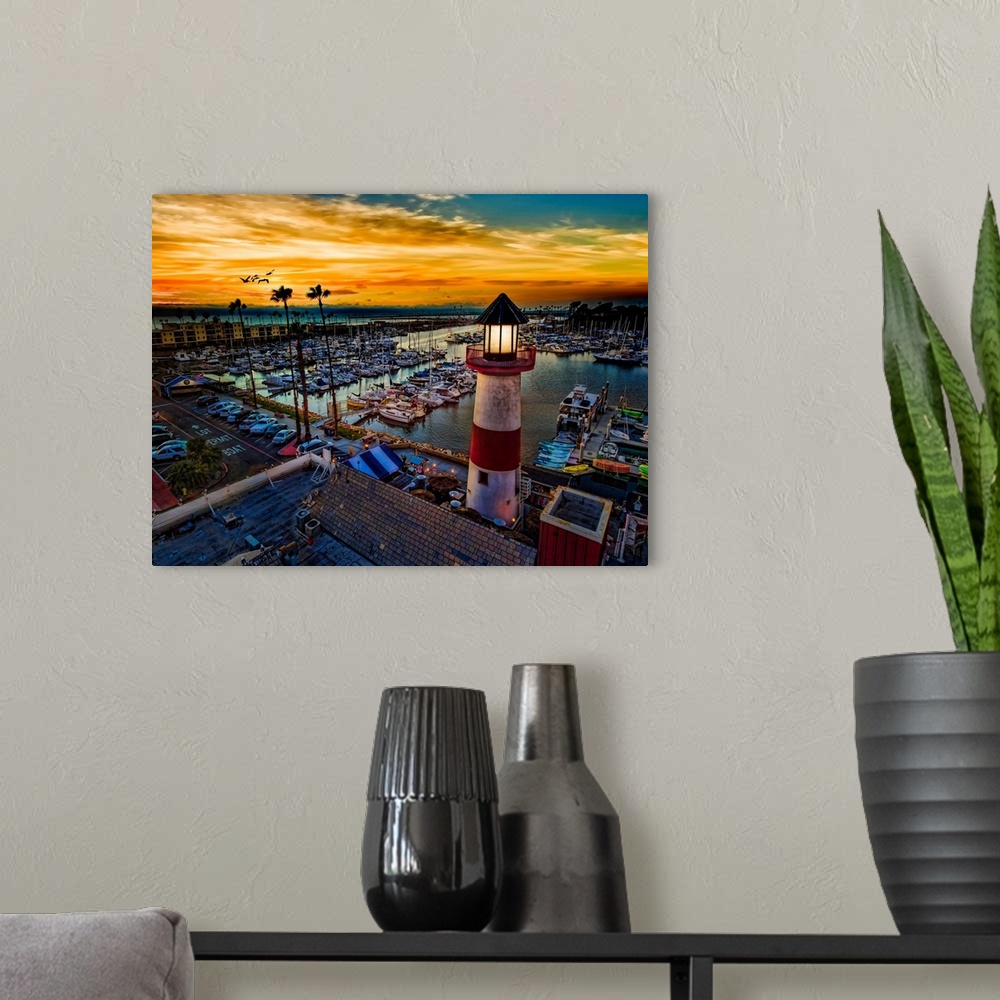 A modern room featuring Pelicans glide over the Oceanside Harbor and the little lighthouse glows. Colorful sunset in Ocea...