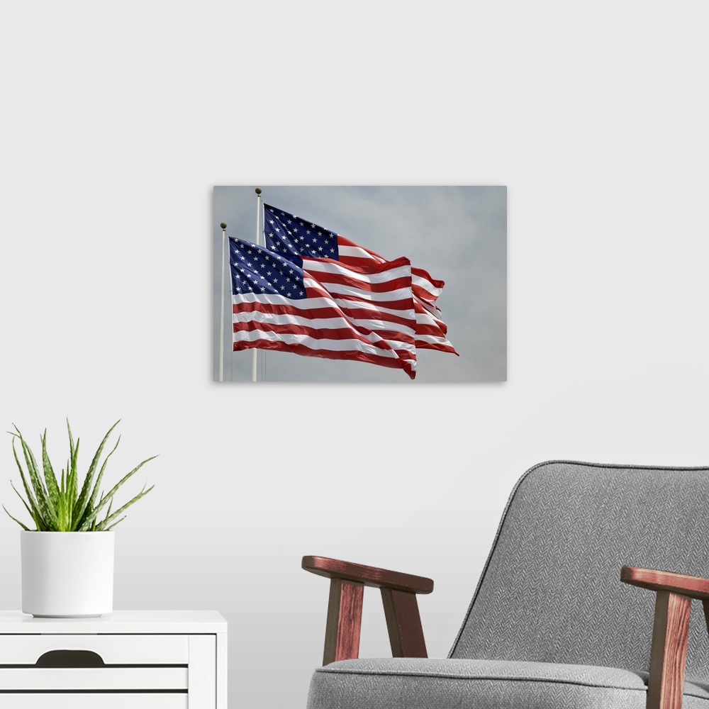 A modern room featuring Two flags flying on a blue sky day