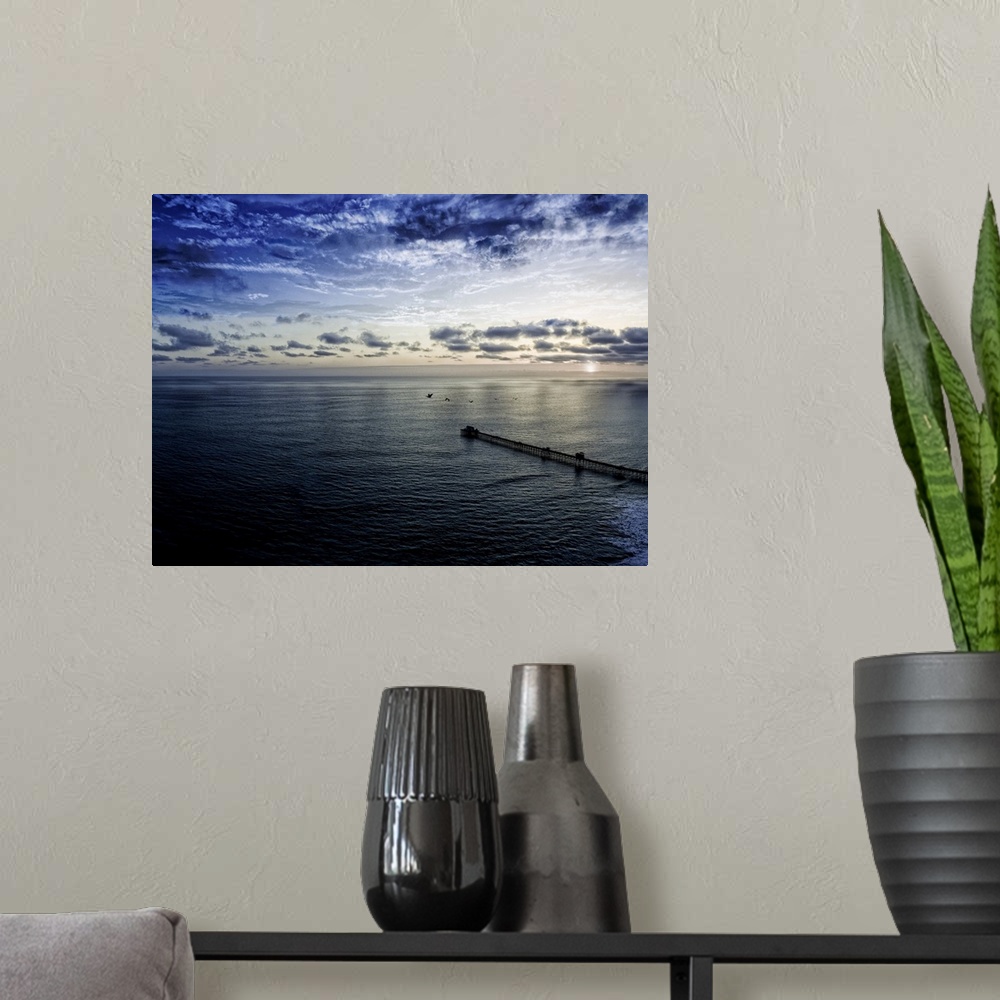 A modern room featuring Pelicans pass over the Oceanside pier at sunset. Oceanside is 40 miles North of San Diego, Califo...