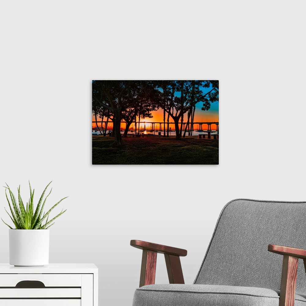 A modern room featuring A colorful view of San Diego Bay and Coronado Bay Bridge through trees on Coronado Island.