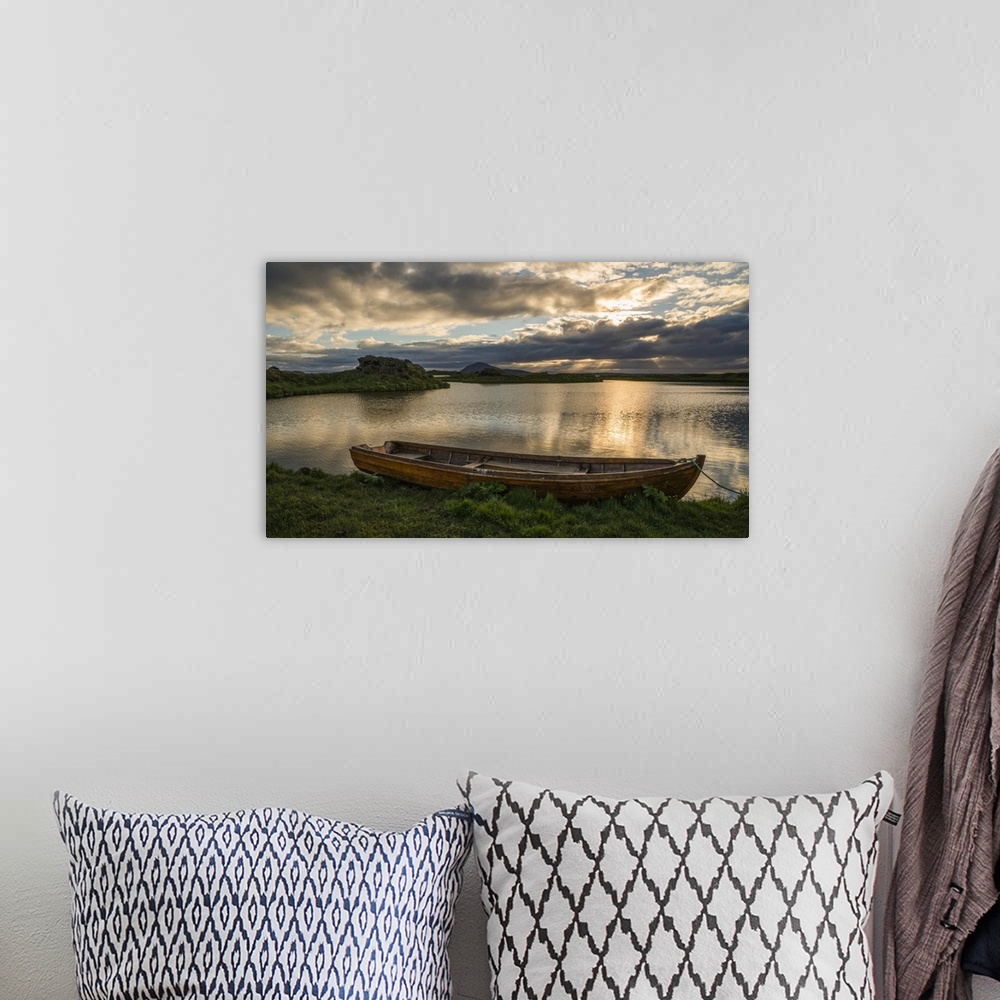 A bohemian room featuring A boat lies in a placid Lake Myvatn, North Iceland at sunset, Iceland