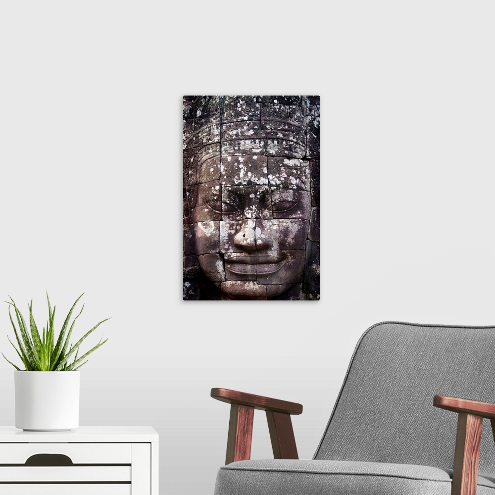 A modern room featuring A face sculpture on a stone wall at angkor wat, Cambodia