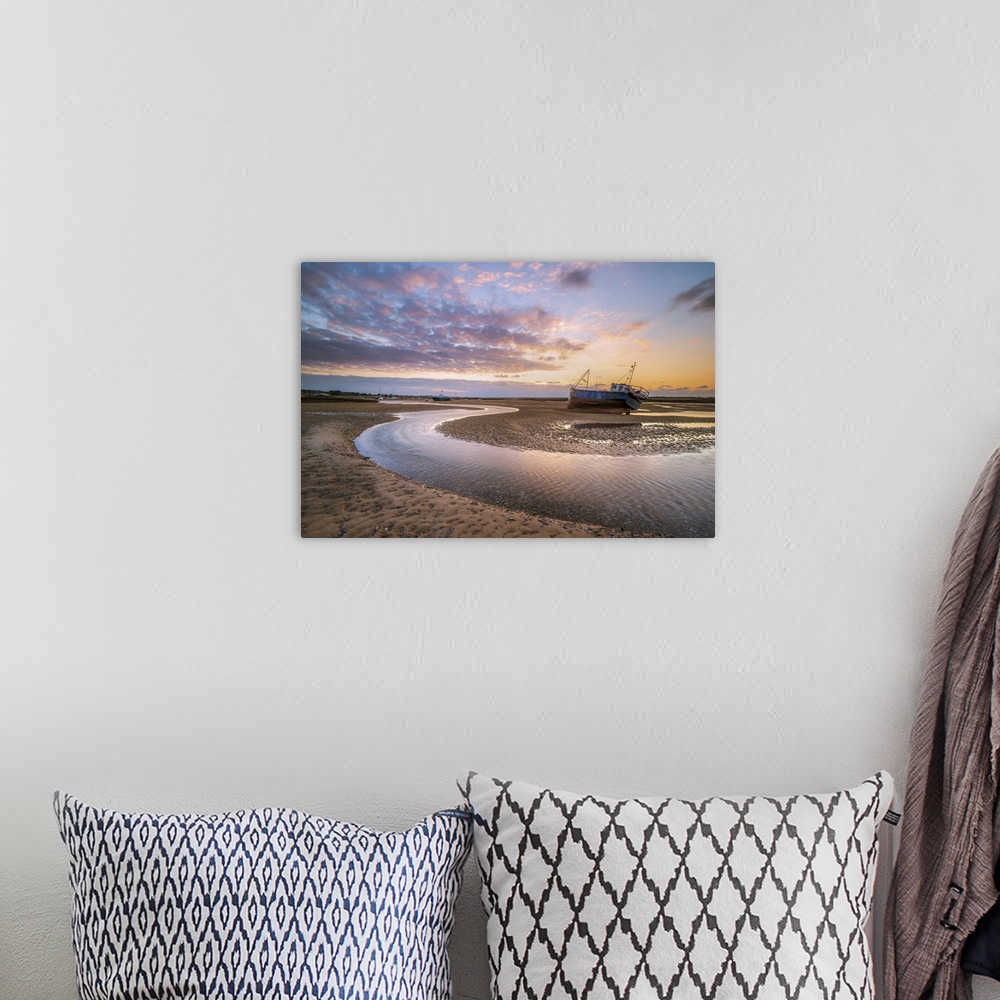 A bohemian room featuring A fishing boat next to a winding river through the sand during sunset at Mow Creek at Brancaster ...