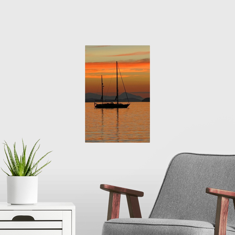 A modern room featuring Beautiful photograph of a sail boat sitting in the water with mountains in the background as the ...