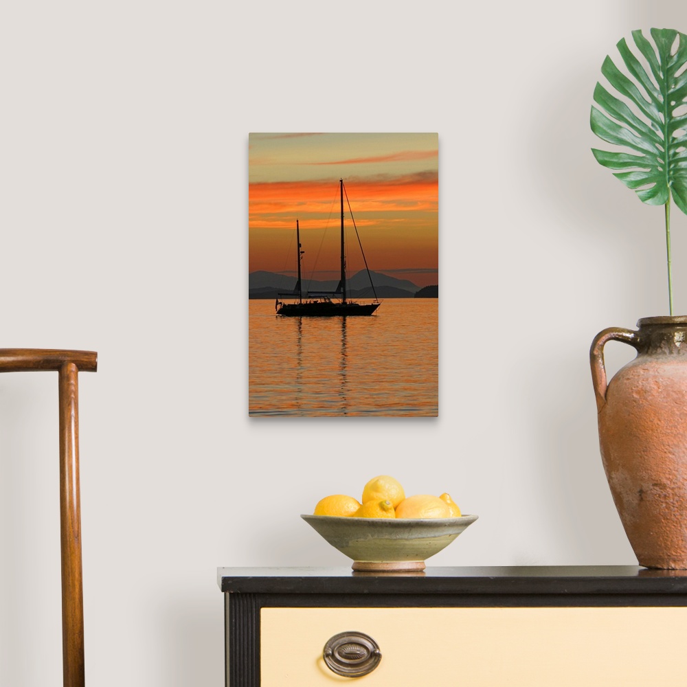 A traditional room featuring Beautiful photograph of a sail boat sitting in the water with mountains in the background as the ...