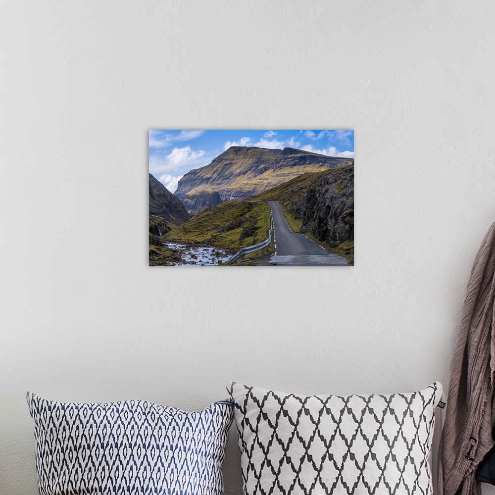 A bohemian room featuring A scenic empty straight uphill road leading to Saksun on the Faroe Islands.