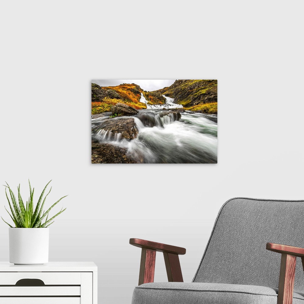 A modern room featuring A stream flows past on the West Fjords on its way to the ocean; Iceland
