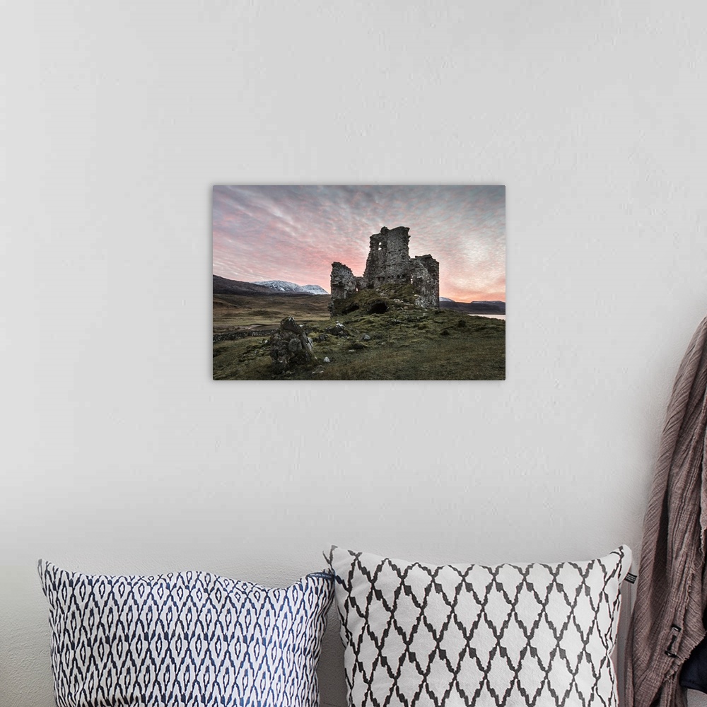 A bohemian room featuring A view toward Ardvreck castle at sunset.