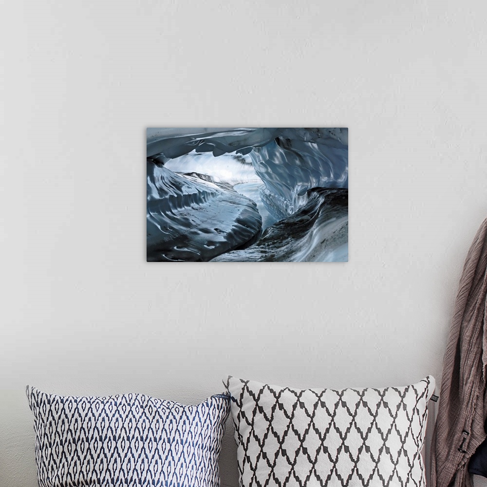 A bohemian room featuring A photograph inside a tunnel that was formed by a water channel inside a glacier.