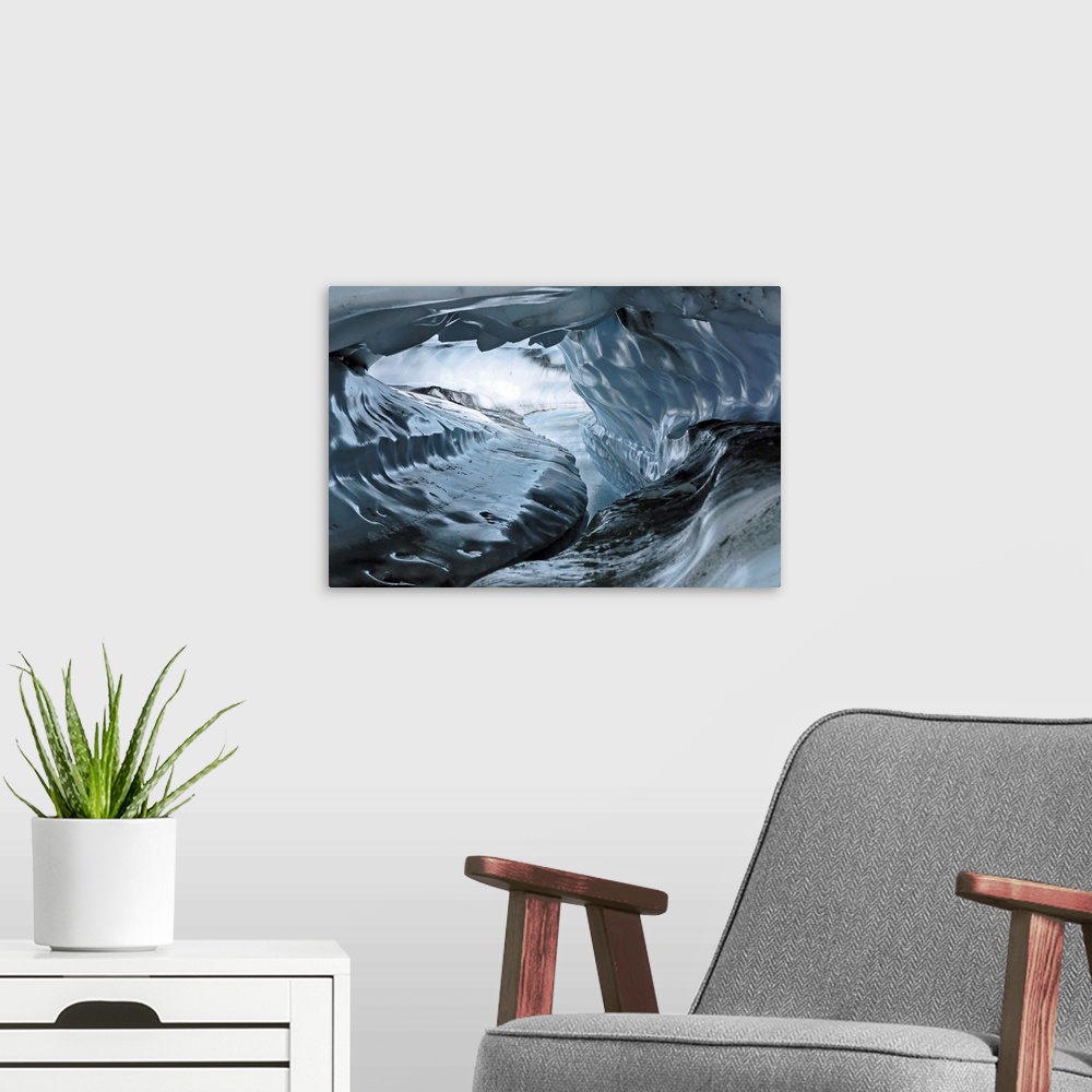 A modern room featuring A photograph inside a tunnel that was formed by a water channel inside a glacier.