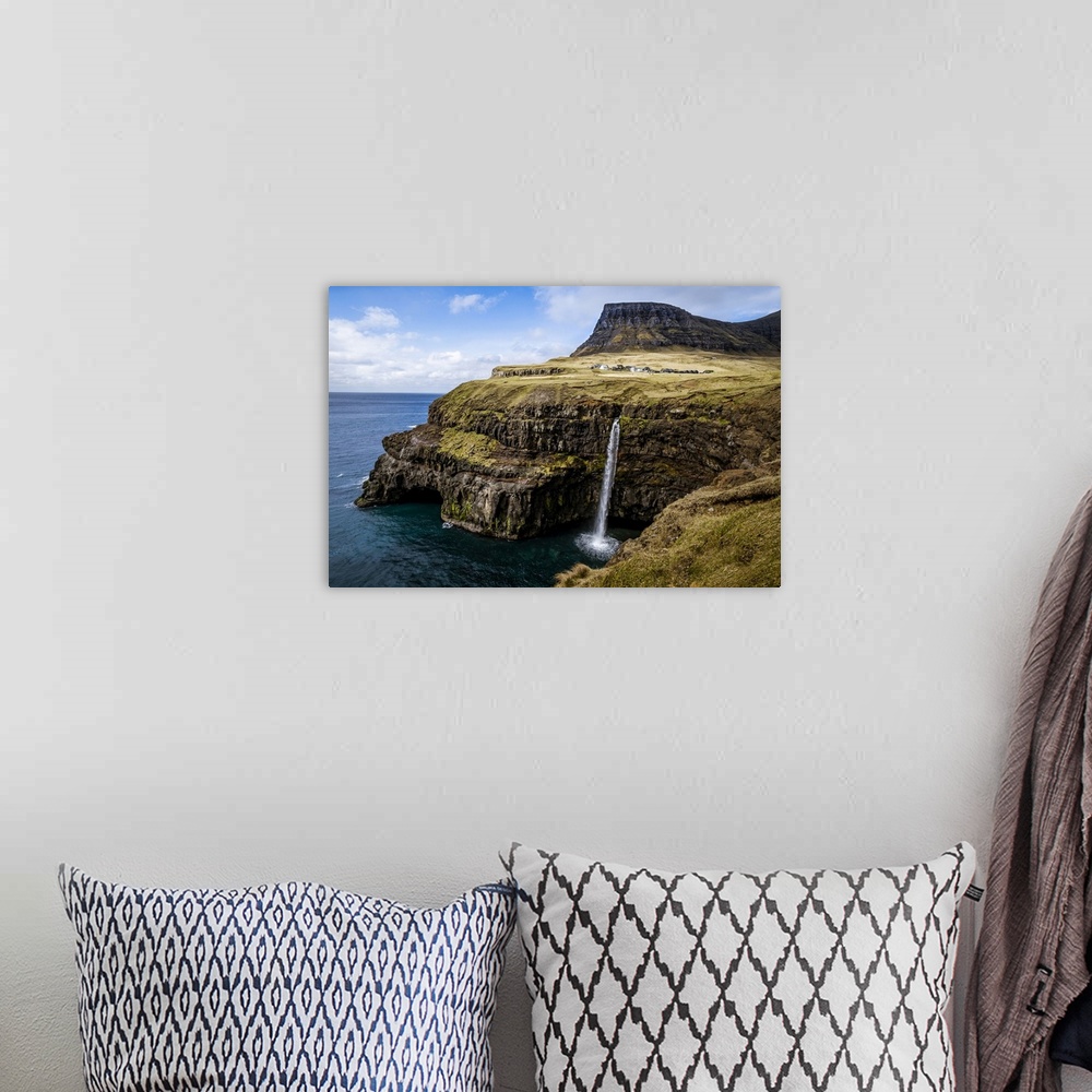 A bohemian room featuring A waterfall cascades down a dramatic rockface on the Faroe Islands.