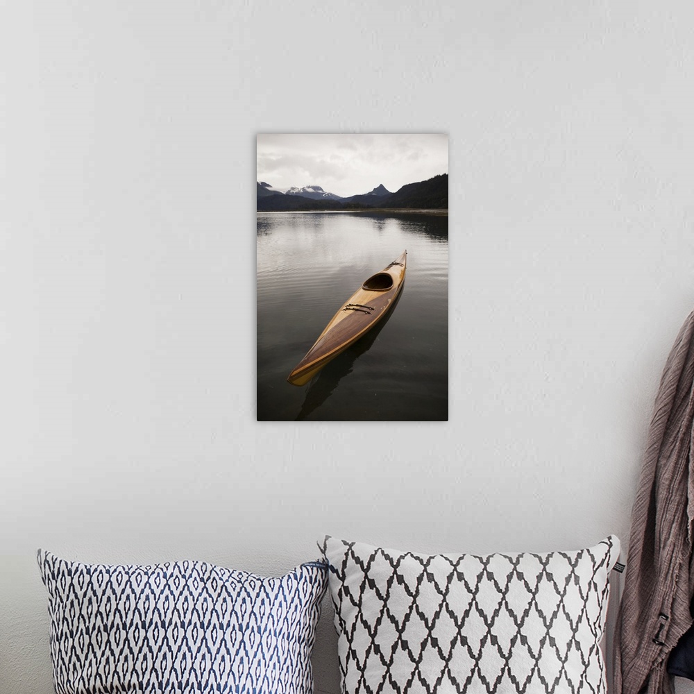 A bohemian room featuring A Wooden Kayak Sits On Tranquil Water With A View Of The Mountains In The Background, Kachemak Ba...