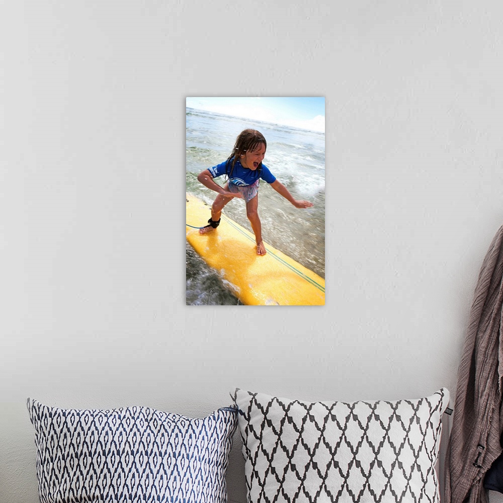 A bohemian room featuring A young girl on a yellow surfboard, Gold Coast, Queensland, Australia