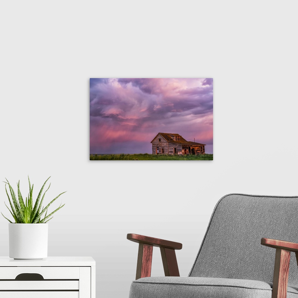 A modern room featuring Abandoned barn on farmland with storm clouds glowing pink; Val Marie, Saskatchewan, Canada
