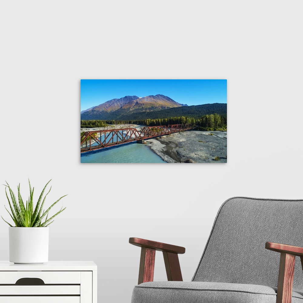 A modern room featuring An aerial scenic of the Alaskan Railroad trestle crossing the Snow River on a sunny summer day in...