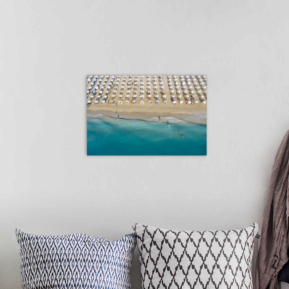 A bohemian room featuring An aerial view of Kathisma beach in Lefkada with people enjoying the deep blue waters.