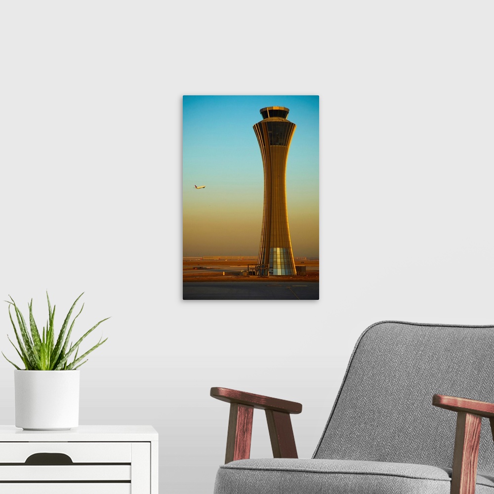 A modern room featuring An Airplane Flies Past The Air Traffic Control Tower At The Beijing Airport, China